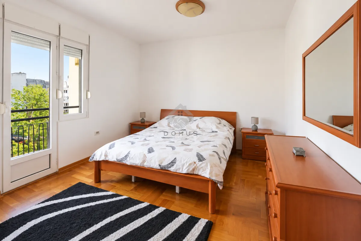 Bedroom with a double bed, wooden furniture, and access to a balcony.
