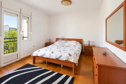 Bedroom with a double bed, wooden furniture, and access to a balcony. - image 7