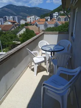 Furnished patio set with a table and chairs on the balcony. - image 13