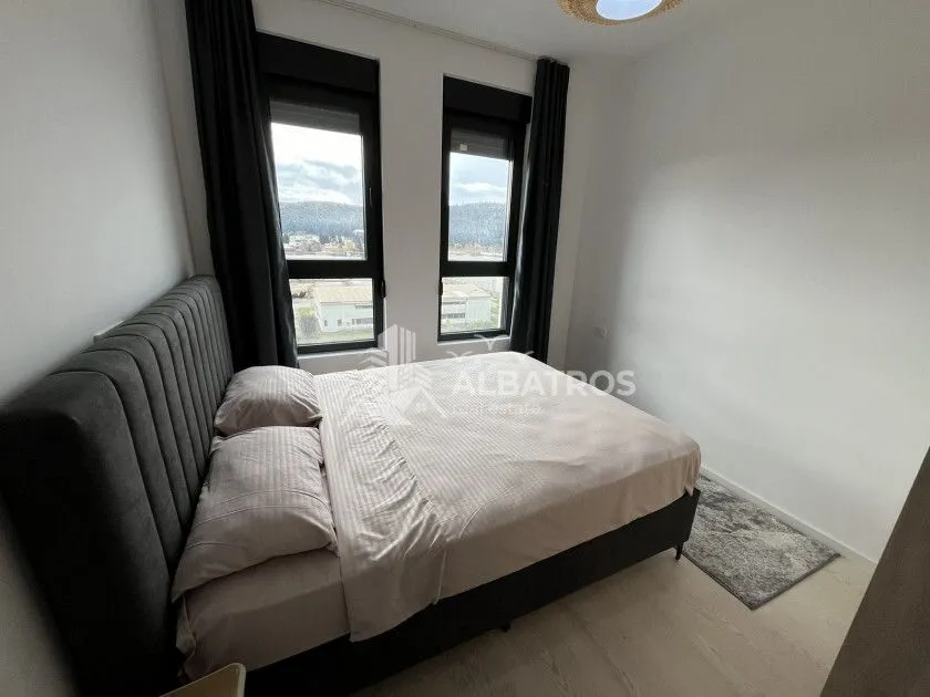 Bedroom with a large double bed and two windows.