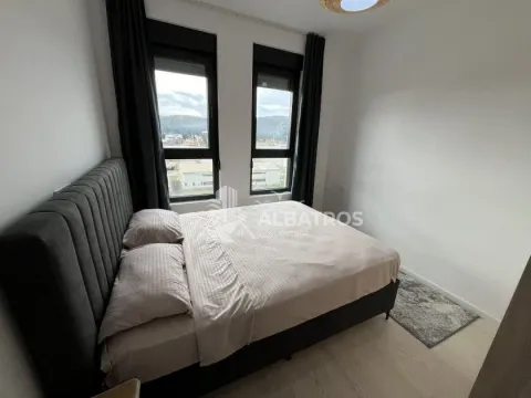 Bedroom with a large double bed and two windows. - image 7