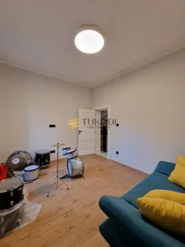 Living room with a sofa and a drum kit set up. - image 12