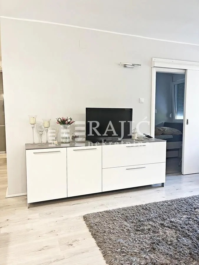 Living room with a white chest of drawers and a TV.