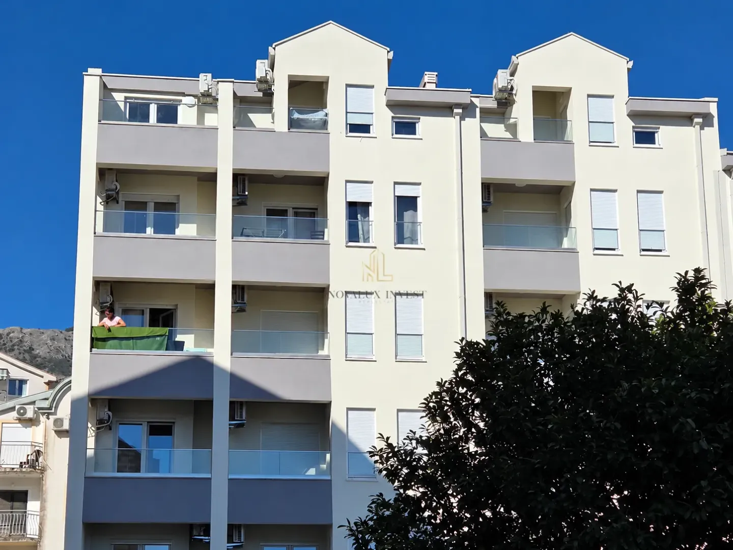 Front view of a multi-story residential building with terraces.