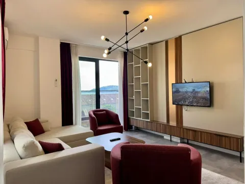 Modern living room with a sofa, TV, and shelving unit. - image 7