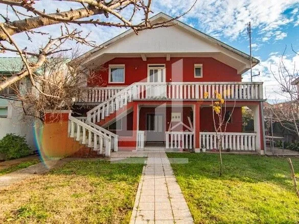 View of the front exterior of the house with a yard and outdoor staircase.