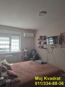 Spavaća soba sa bračnim krevetom, klima uređajem i televizorom na zidu. - image 12