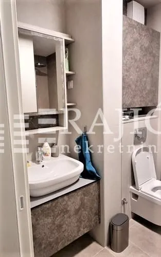 Modernly equipped bathroom with a washbasin and toilet.