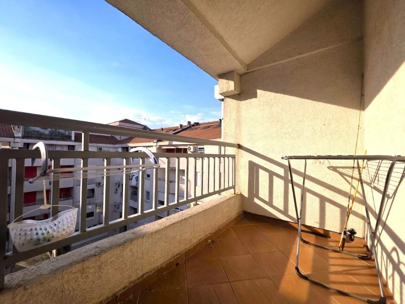 Covered balcony with ceramic tiles and a view of the neighborhood.