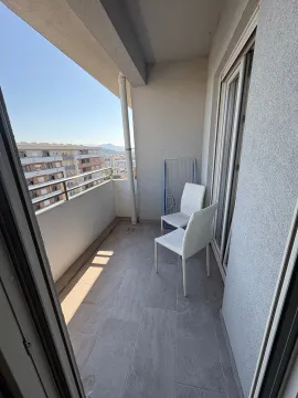Covered balcony with chairs and city view. - image 6
