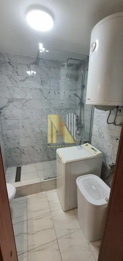 Kupatilo sa tuš kabinom, veš mašinom i bojlerom.