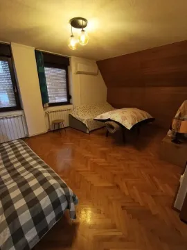 Spavaća soba sa krevetom, drvenim parketom i drvenom oblogom na zidu. - image 32