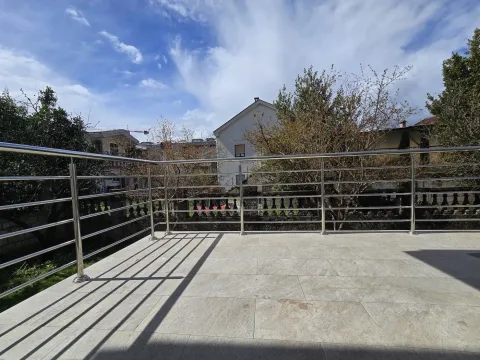 Spacious tiled terrace with a metal railing and a view of the surrounding houses. - image 29