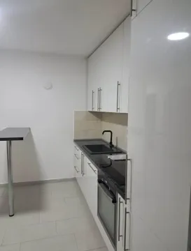 Manja bijela kuhinja sa tamnom radnom pločom i šankom. - image 5