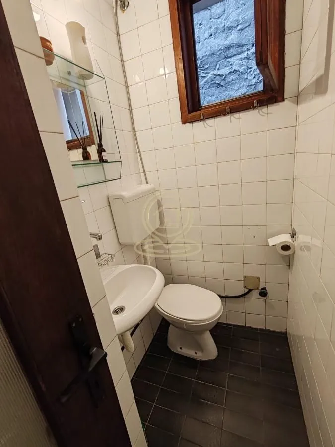 Smaller bathroom with sanitary ware and white wall tiles.