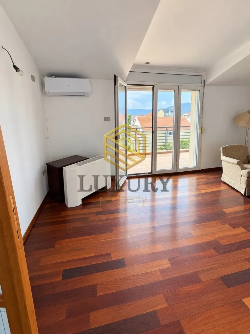 Living room with wooden flooring and access to the terrace.