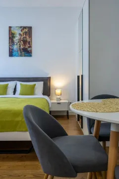 Uređena spavaća soba sa bračnim krevetom i trpezarijskim kutkom. - image 4