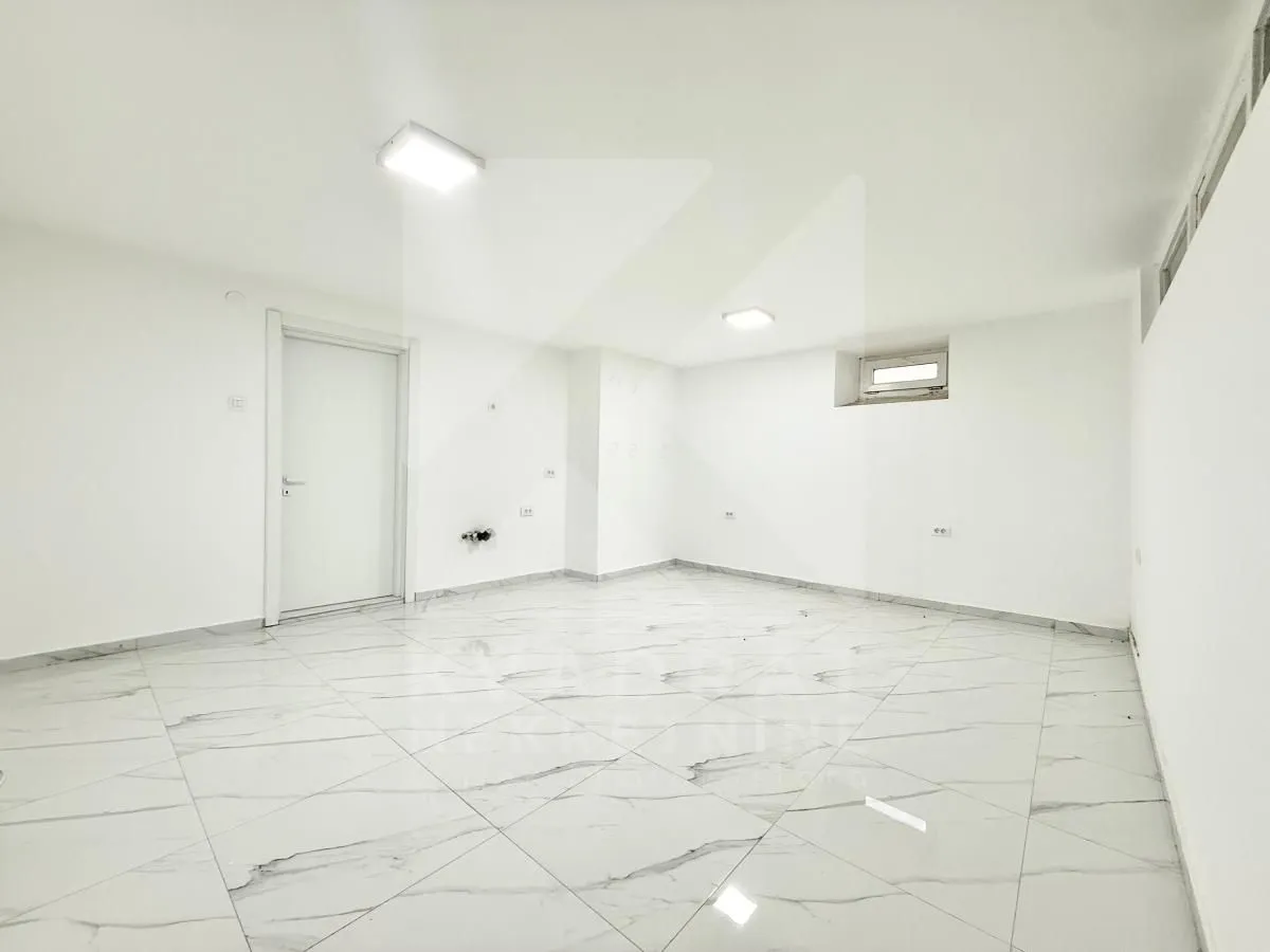 Empty room with white walls and tiled floor.