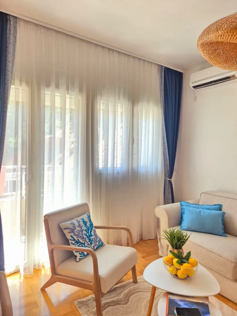 Bright living room with sofa and large windows.