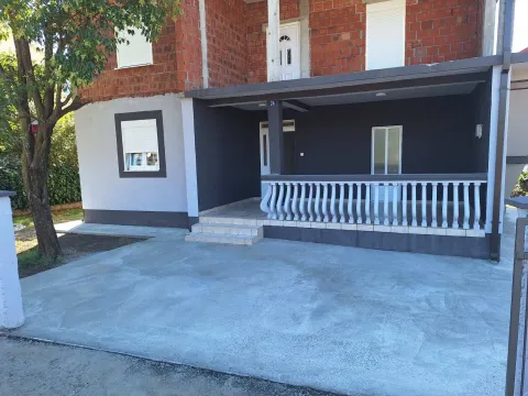 Exterior view of a house with a terrace and a concrete yard. - image 7