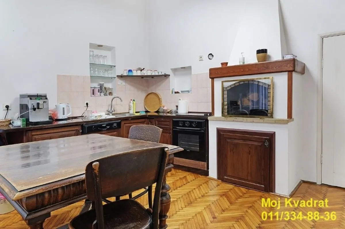 Tradicionalna kuhinja sa trpezarijskim stolom i ugrađenim kaminom.