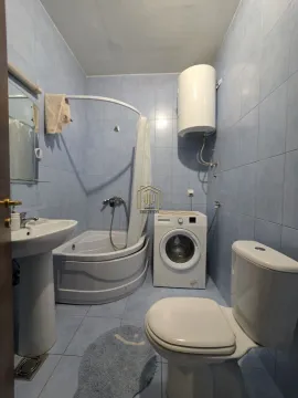 Kupatilo obloženo pločicama sa kadom, umivaonikom, WC šoljom i mašinom za veš. - image 12