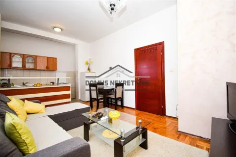 Living room with sofa, dining table and kitchen in the background. - image 3