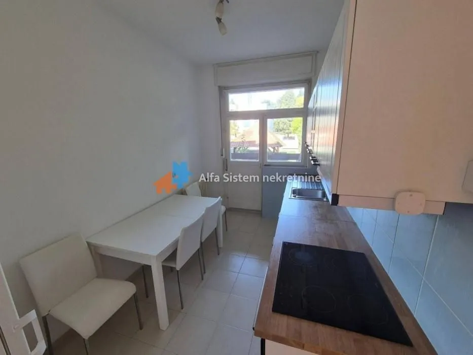 Small kitchen with a dining table and access to the terrace.