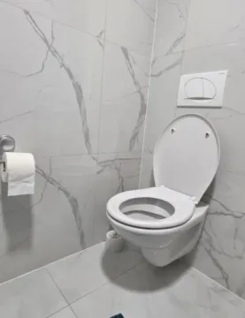 Moderno opremljeno kupatilo sa bijelim keramičkim pločicama i konzolnom wc šoljom. - image 7
