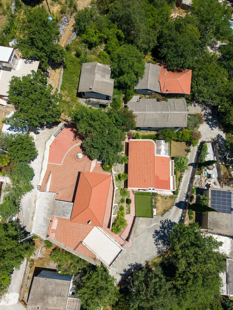 Pogled iz vazduha na porodičnu kuću sa dvoriijem i zelenilom.