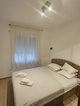 Namještena spavaća soba sa bračnim krevetom i prozorom. - image 7