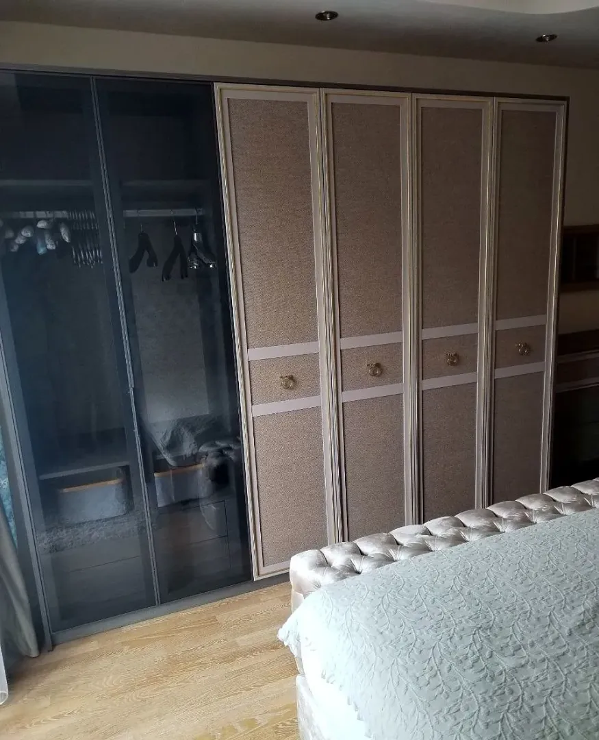 Spacious bedroom with a large wardrobe and a double bed.