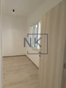 Empty room with laminate flooring and white walls with an open door. - image 5