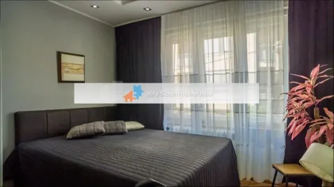 Bedroom with a double bed and a large window with curtains. - image 3
