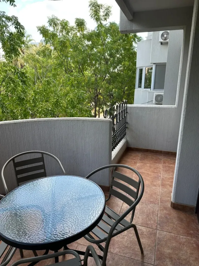Furnished balcony with a table and chairs and a green view.