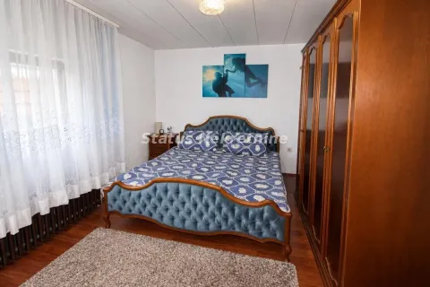 Spavaća soba sa bračnim krevetom i drvenim ormarom. - image 3