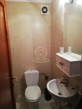 Manje kupatilo obloženo keramičkim pločicama sa toaletom, umivaonikom i ogledalom. - image 14