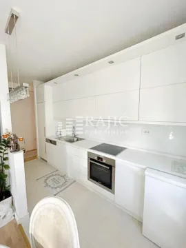 Modern white kitchen with built-in appliances and white countertops. - image 8