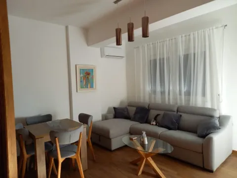 Bright living room with a sectional sofa and a dining table. - image 11
