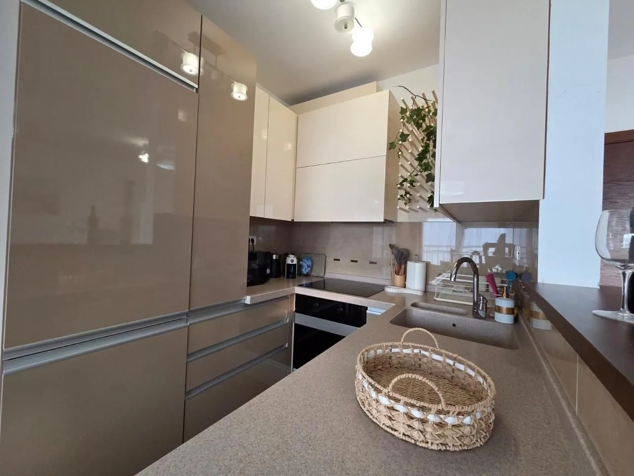 Modern kitchen with beige cabinets and built-in appliances.