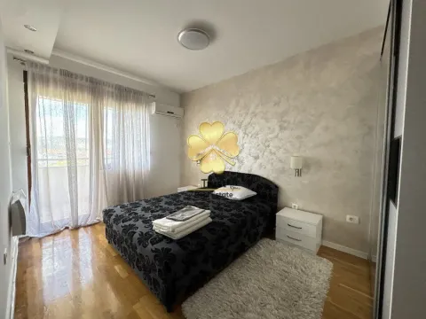 Furnished bedroom with a double bed, white nightstands, and access to a terrace. - image 11
