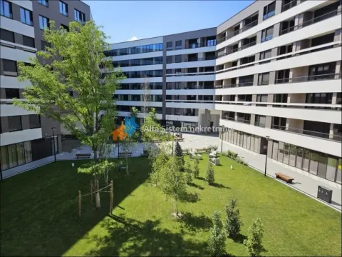 Unutrašnje dvorište sa zelenom površinom i stazama okruženo modernom stambenom zgradom. - image 3