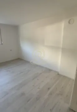 Prazna soba sa belim zidovima i laminatom na podu. - image 8