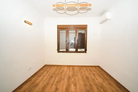 Empty room with wooden flooring, a window, and an air conditioning unit. - image 4