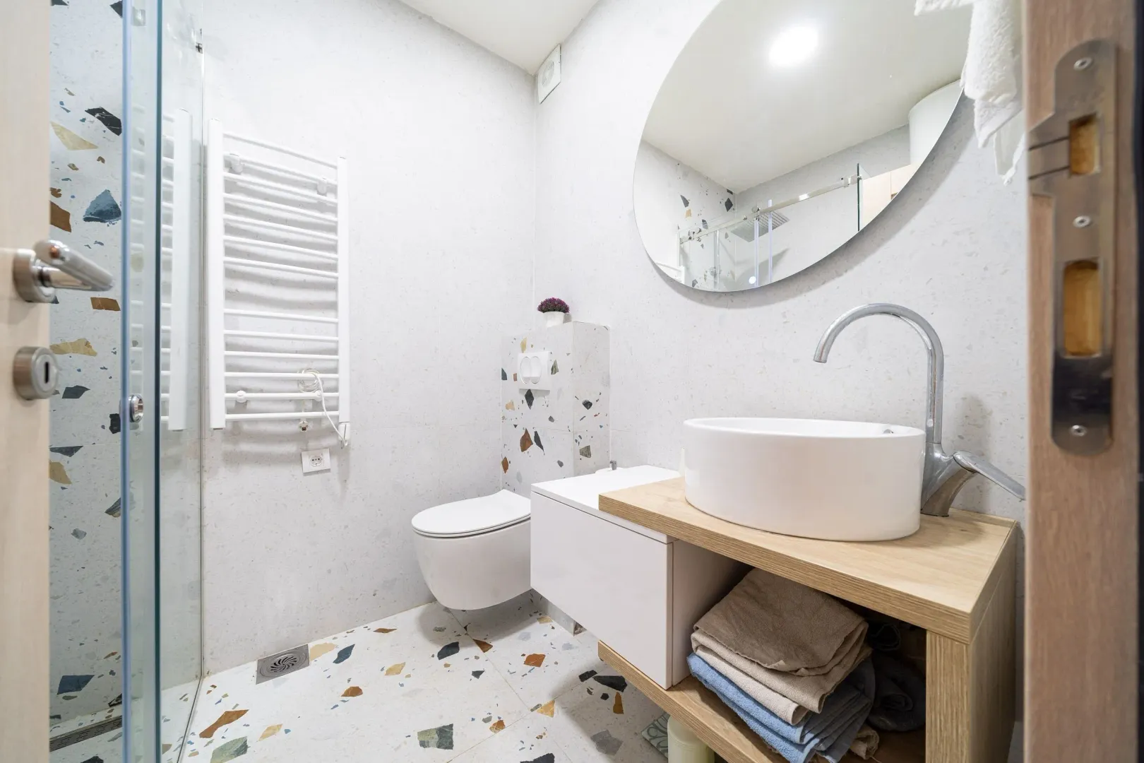 Modernly equipped bathroom with a washbasin and a walk-in shower.
