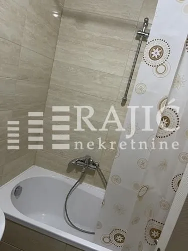 Small bathroom with a bathtub and shower curtain.