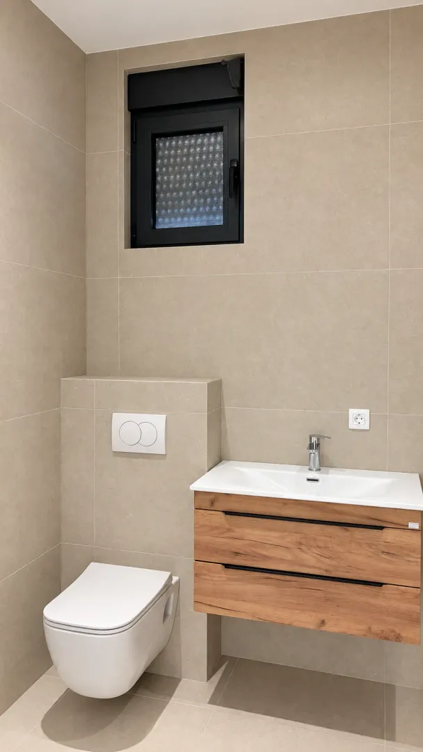 Moderno opremljeno kupatilo sa umivaonikom i ugradnom wc šoljom.