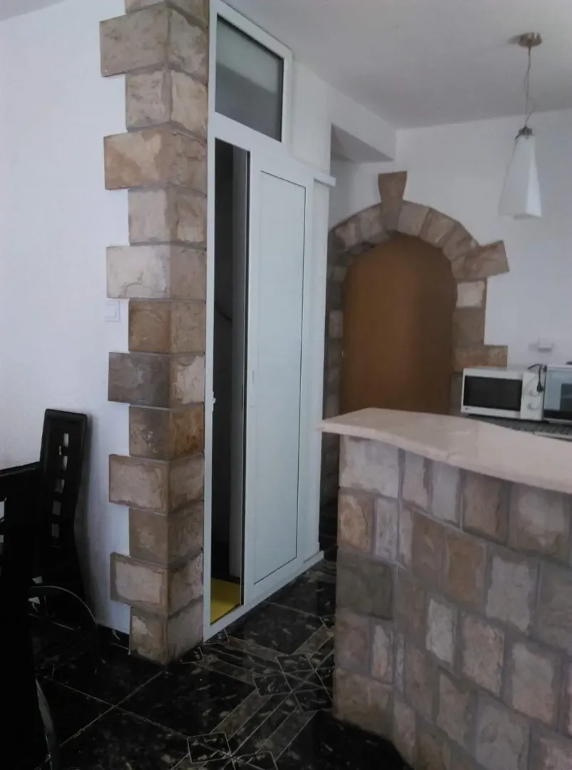 Unutrašnjost kuhinje sa šankom i detaljima od kamena.