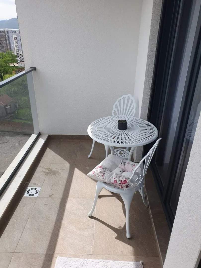 Manji namješteni balkon sa stocem i dve stolice.
