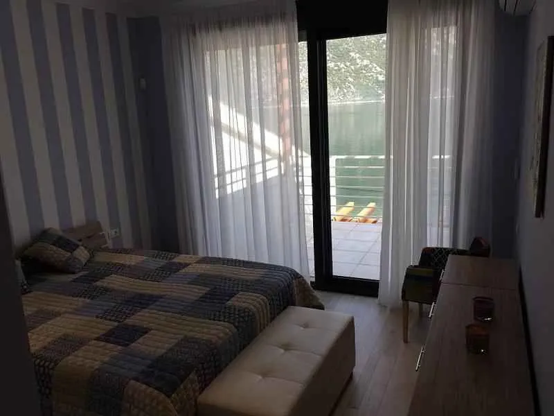 Spavaća soba sa francuskim ležajem i izlazom na terasu.